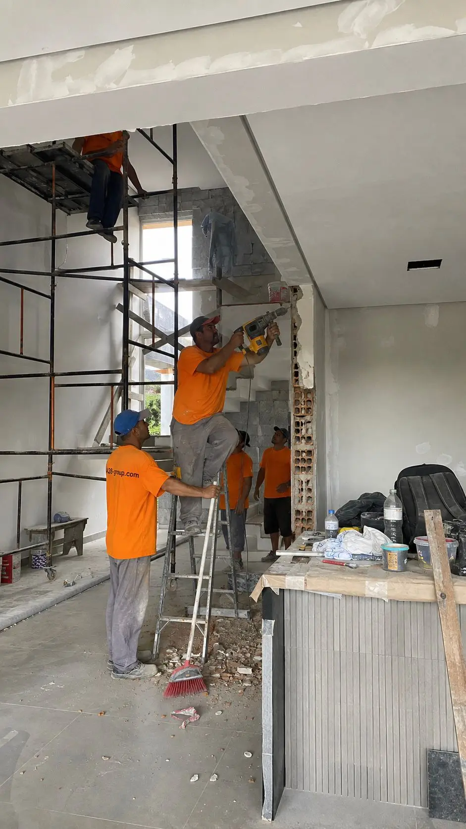 Fachada de hormigón de una obra nueva en ejecución, con andamio en primer plano