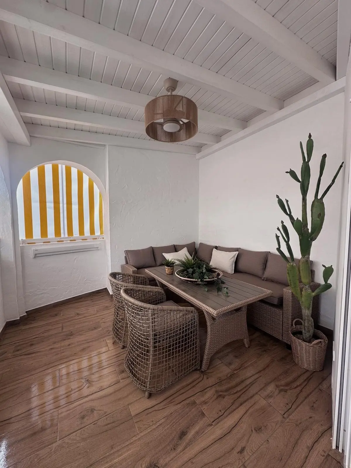 Covered porch with rattan furniture after a full renovation in Marbella