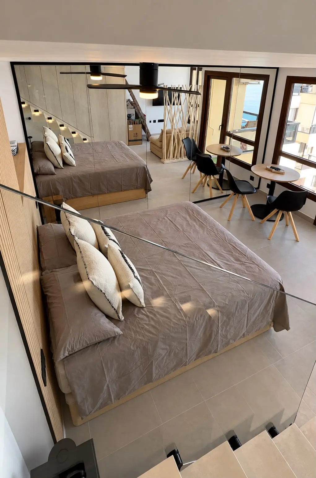 Bedroom with a mirrored wall and sea views after a full renovation in Marbella
